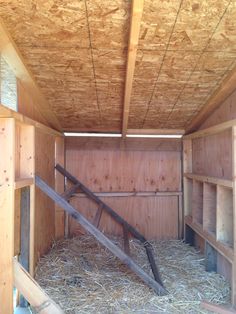 the inside of a barn with hay in it