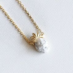 "Stone Pineapple Necklace Beautifully crafted white or blue Howlite marble stone pineapple pendant necklace. Pineapple leaf and necklace plated in 18K Gold, stone in on pineapple part only. Dipped in Gold. * Brass Casting * Lead & Nickel Free ◾ MEASURES * Necklace Length: 16\" * Pendant Width: 0.25\" * Pendant Height: 0.5\" * Closure: Lobster Claw ◾ CARE: * Treat delicately to extend its life. Clean only with a soft, dry cloth. * Chain/Pendants are gold plated so please avoid contact around water such as shower, pool, spa, etc. * Do not wear during sleep or workouts. * Avoid contact with chemicals, sweat, salts, and oils. Your jewelry will last a long time if you care for it properly. ◾ PLEASE NOTE: Business days do not include weekends & holidays, as the postal service does not operate on Jewelry Stacking, Pineapple Necklace, Blue Howlite, Etsy Bridesmaid Gifts, Pool Spa, White Turquoise, Marble Stone, Gold Stone, Marble Stones