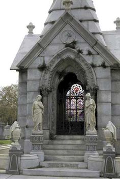 an old church with statues and a stained glass window