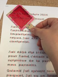 a hand is holding a piece of paper and writing on it with a red marker