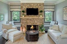 a living room filled with furniture and a flat screen tv mounted on the wall above a fire place