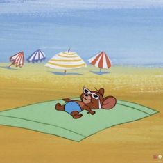 a cartoon bear laying on top of a blanket in the sand near beach umbrellas