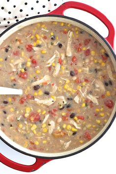 a red pot filled with chicken and corn soup