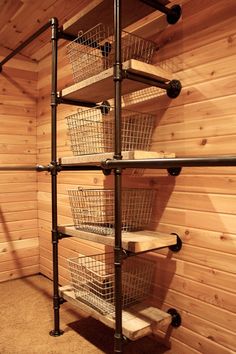 the inside of a wooden sauna with metal pipes and baskets on it's shelves