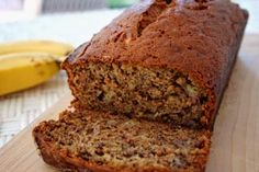 a loaf of banana bread sitting on top of a cutting board next to a banana