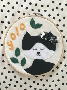 a black and white polka dot table cloth with a hand embroidered hoop that says hello on it