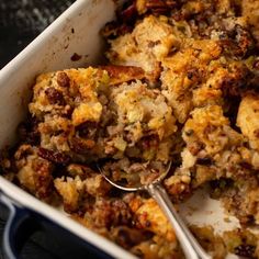 a casserole dish with stuffing and spoons in it, ready to be eaten