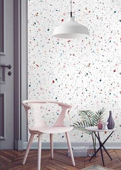 a chair and table in front of a white wall with colorful dots on the wall