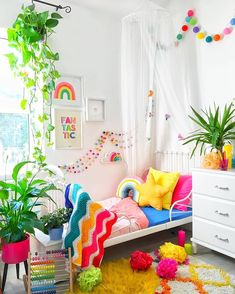 a bedroom with lots of plants and decorations on the walls, including a rainbow colored bed