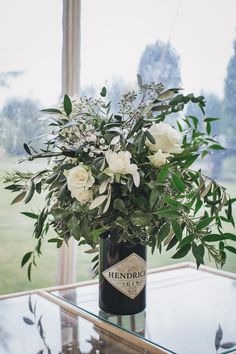 a vase filled with white flowers on top of a glass table