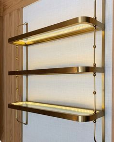 a wall mounted shelf with three lights on it's sides and two shelves below