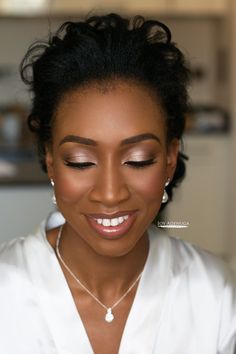 a woman in a white shirt is smiling and looking at the camera with her eyes closed