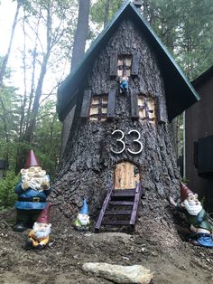 a tree house with gnomes around it and numbers on the front door is shown