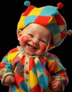 a baby wearing a clown costume and smiling