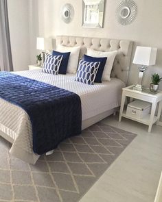 a bed with blue and white pillows in a bedroom