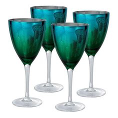 four green wine glasses sitting next to each other