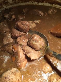 meatballs are being cooked in a pot with a ladle