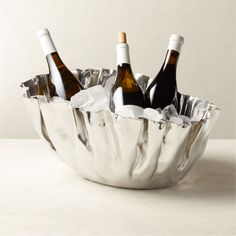 three bottles of wine in a silver bowl