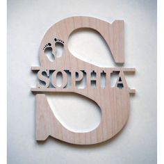 a wooden sign that says sophia with a baby's feet on it