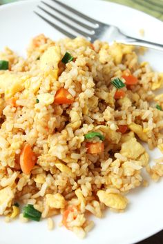 a white plate topped with fried rice and veggies