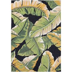 an area rug with green and yellow tropical leaves on it, in front of a black background