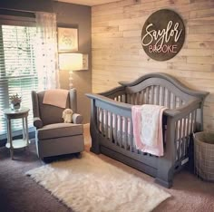 a baby's room with a gray crib and white rug