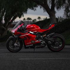 a red motorcycle is parked on the street