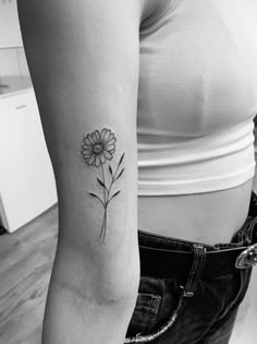 a woman's arm with a flower tattoo on the left side of her body