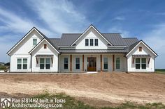 a large white house sitting on top of a dirt field