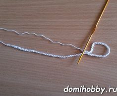 a close up of a knitting needle on a wooden surface with the end of a crochet hook