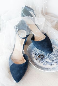 two pairs of blue high heel shoes sitting on top of a plate