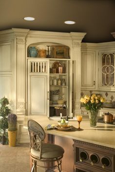 a kitchen with white cabinets and an island in front of the stove top is filled with flowers