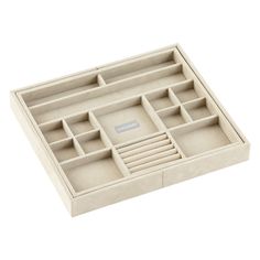 a white box with compartments and dividers on top of the trays is shown