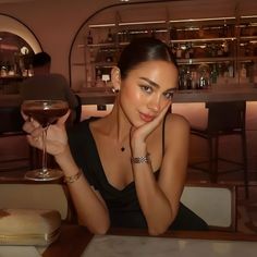 a woman sitting at a table with a glass of wine