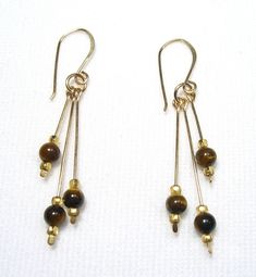 These earrings are Tiger's Eye Their overall length including earwires is about 2". The tiger's eye stones are 4 mm. They are Gold Filled. Handmade by us.  Lyn's Jewelry, in business operating out of Sunny Syracuse since 1989. Tiger Eye Earrings Jewelry, Tigers Eye Jewelry, Pretty Trinkets, Eye Drop, Tiger Eye Earrings, Tiger Eye Jewelry, Drop Earrings Gold, Gold Sign, Design Board