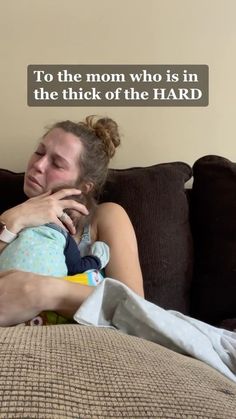 a woman holding a baby on top of a couch with the caption to the mom who is in the thick of the hard