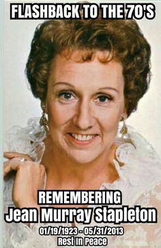 an old photo of a woman with curly hair and blue eyes smiling for the camera