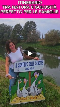 a woman standing next to a sign with ducks on it