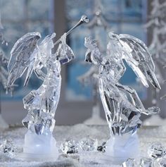 two crystal angel figurines standing next to each other