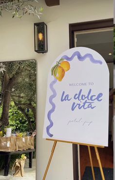 a welcome sign is displayed in front of a door with a mirror behind it that reads, welcome to la dolce vita