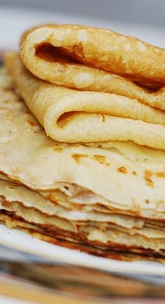 a stack of tortillas sitting on top of a white plate