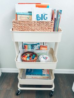 a cart filled with books and magazines on top of a hard wood floor