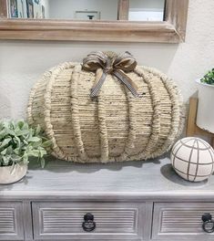 a large woven pumpkin sitting on top of a dresser