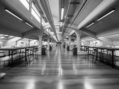 an empty restaurant with tables and chairs in it's long, open hallway that leads to the second floor