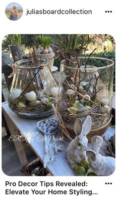 two glass vases filled with plants and eggs on top of a table next to an easter bunny