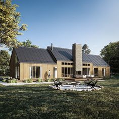 a large house with two chairs and a table in front of it on the grass