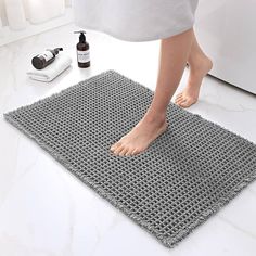 a person standing on top of a bathroom rug