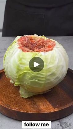 a head of cabbage sitting on top of a wooden cutting board