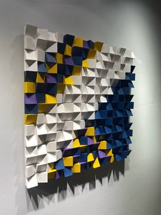 an abstract piece of art made out of folded origami pieces on a wall