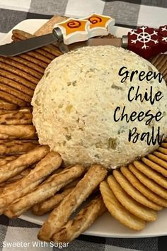 a cheese ball surrounded by crackers on a plate with the words green chile cheese ball